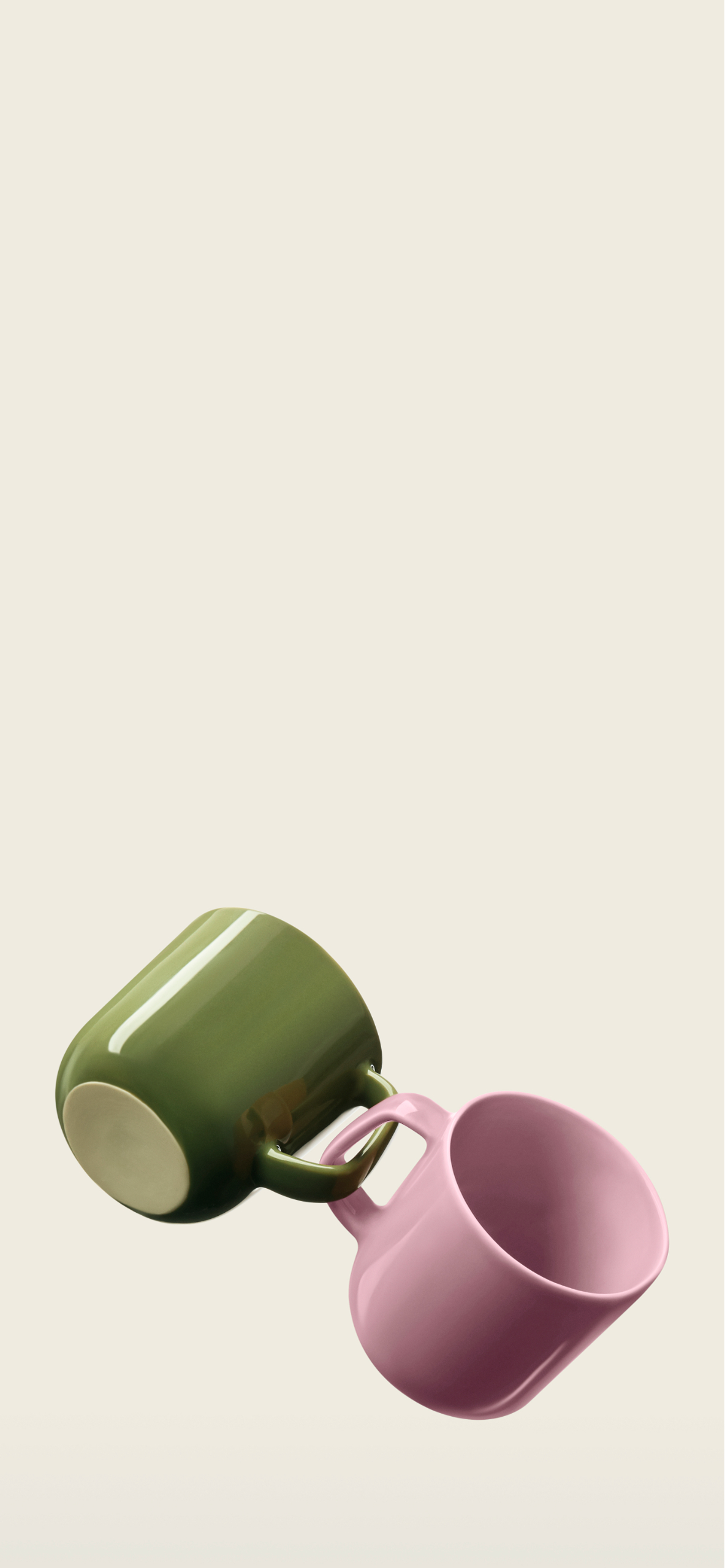 A green and pink mug, linked by their handles.
